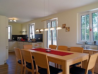 Großer Esstisch und offene Küche im Erdgeschoss